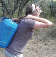 Taken on a water walk by the village women, Jackie attempts to carry a 50 lb. jug of water back to the village.