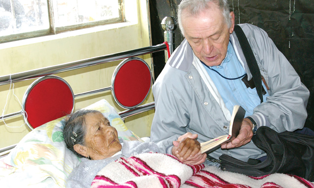 Scarboro missioner Fr. Charlie Gervais visits an elderly parishioner. Ecuador.