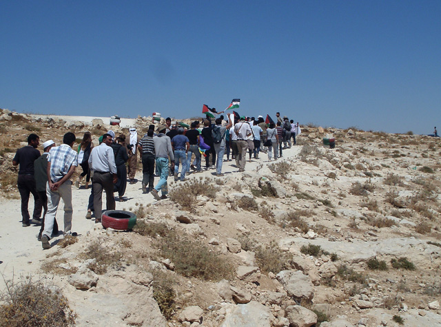 Villagers of the South Hebron Hills take part in a nonviolent action, walking to the gates of a Jewish settlement where soldiers are stationed. August 2012.
