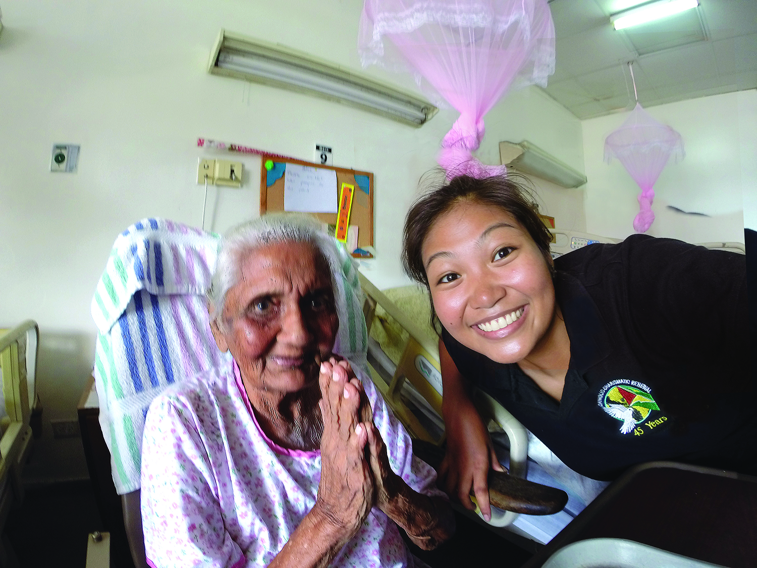 Scarboro missioner Ashley Aperocho visits a Hindu resident at a nursing home. Guyana.